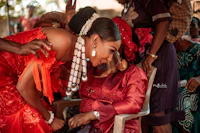 a woman in a red dress is touching a woman in a red dress
