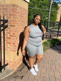 a black woman in a grey tank top and shorts