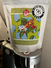 a bag of coffee beans sitting on top of a coffee machine