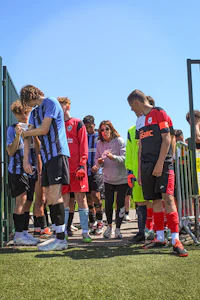 a group of people standing around a soccer field
