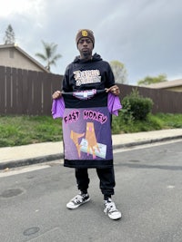 a man holding up a shirt that says fast money