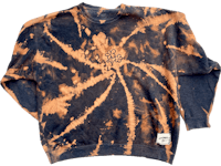 a tie dye sweatshirt with a black and orange design