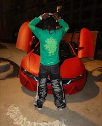 a man standing next to a red bmw