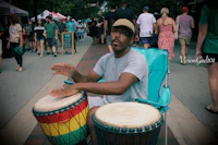 a man playing a djembe at a festival
