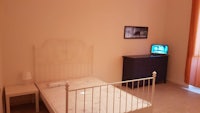 a small bedroom with a bed and a tv