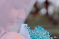 a woman holding a bouquet of blue flowers