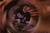 a man playing an electric guitar in a circular frame