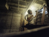 a construction worker working on a ladder in a dark room