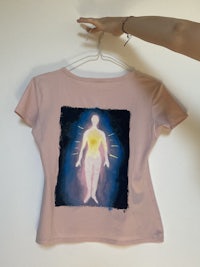 a pink t - shirt with a painting of a man and a woman