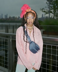 a young woman in a pink sweater and leggings is posing for a photo