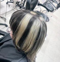 a woman's hair in a salon with black and white highlights