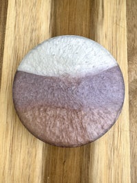 a purple and white plate on top of a wooden table