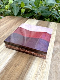 a wooden box with a red, purple, and blue stripe on it