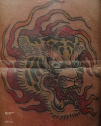 a tattoo of a tiger with flames on it