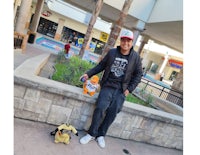 a man with a teddy bear in front of a building