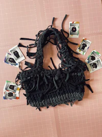 a black crocheted bag laying on top of a piece of paper