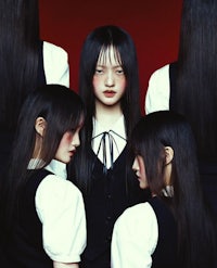 a group of girls with long black hair standing in front of a red background