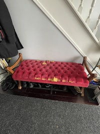a bench with a red cushion in front of a staircase