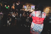 a woman in a dress standing in front of a crowd