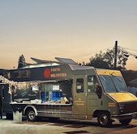 a food truck is parked outside at dusk