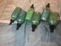 a group of green glass bottles on a bed