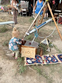 a little girl playing with a water pump at a festival