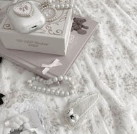 a white bed with pearls and other accessories on it