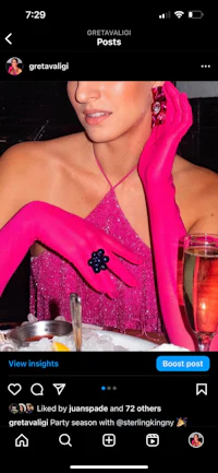 a woman in a pink dress is sitting at a table