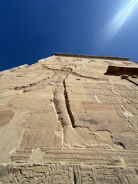 an egyptian building with carvings on the side