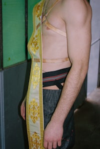 a man wearing a sash with a gold belt