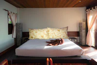 a bed in a room with wooden floors