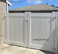a white fence with a white gate in front of it