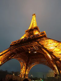 the eiffel tower is lit up at night