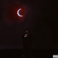 a man standing in front of a dark sky with a crescent moon