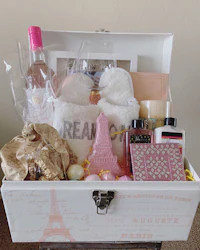 a gift box filled with bath products and a bottle of wine