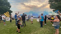 a group of people in a park with blue smoke