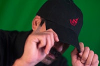 a man wearing a black hat with a red logo on it