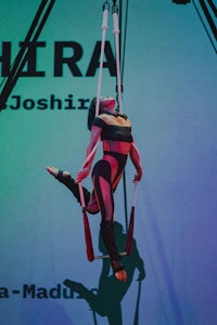 a woman is hanging from a rope on a stage