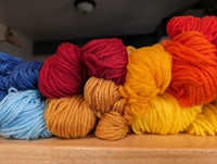 a pile of colorful yarn on a wooden table