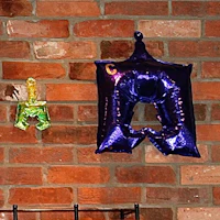 a blue and purple balloon hanging on a brick wall