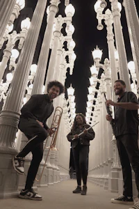 a group of musicians standing in front of white lights