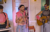 a group of men singing and playing music in a room
