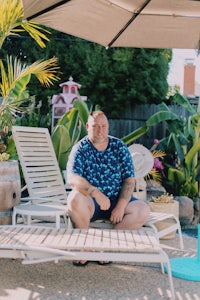 a man sitting under an umbrella