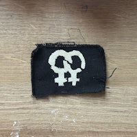 a black patch with a white symbol on it