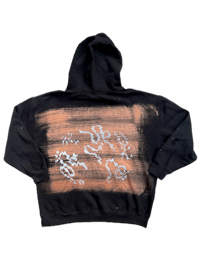 a black and orange hoodie with a drawing on it