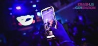 a person holding up a cell phone at a concert