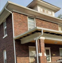 a brick house with a porch and a roof