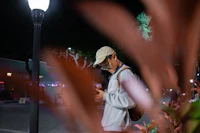 a man looking at his phone in the street at night