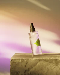 a bottle of perfume sitting on top of a stone wall