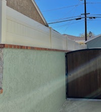 a white fence with a wooden gate next to it